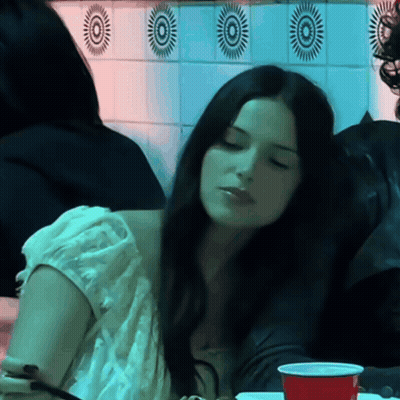 Woman Sitting At Table With Red Cup GIF