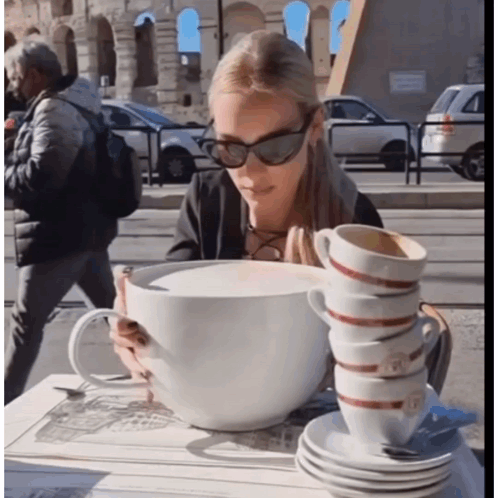 Woman Sitting At Table With Stack Of Coffee Cups GIF