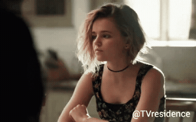 Woman Sitting At Table With TV Residence Watermark GIF
