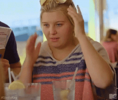 Woman Sitting At Table With Water And Lemon GIF
