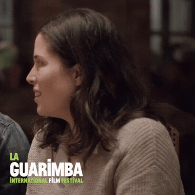 Woman Sitting Before La Guarimba Sign GIF