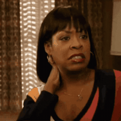 Woman Sitting By Window With Hand On Neck Making Funny Face GIF