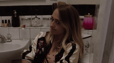 Woman Sitting In Bathroom Next To Sink GIF