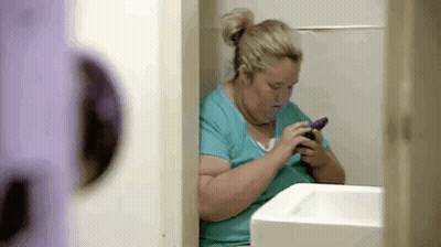 Woman Sitting In Bathroom Using Cell Phone GIF