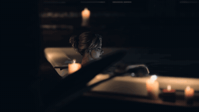 Woman Sitting In Bathtub With Candles GIF
