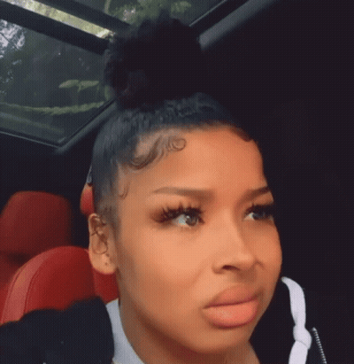 Woman Sitting In Car With Bun On Head GIF