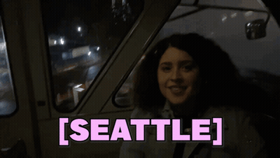 Woman Sitting In Car With Seattle On Screen GIF