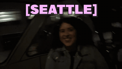 Woman Sitting In Car With Seattle On Screen GIF