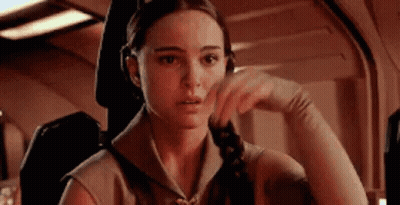 Woman Sitting In Chair Hand On Chin Looking At Camera GIF