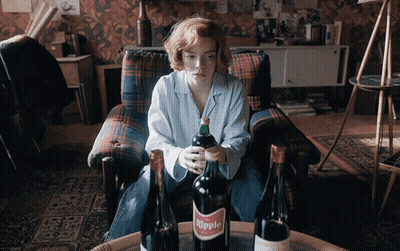 Woman Sitting In Chair Holding Bottle Of Hippie GIF