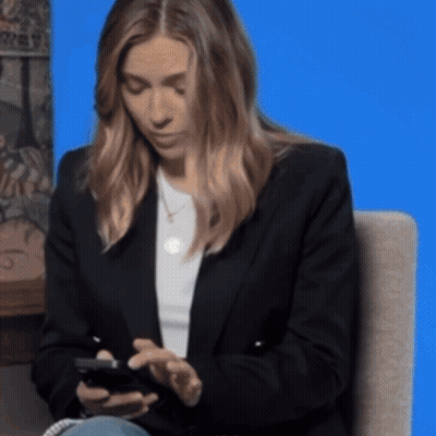 Woman Sitting In Chair Looking At Phone GIF