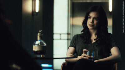 Woman Sitting In Chair Next To Whiskey GIF