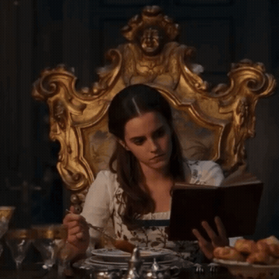 Woman Sitting In Chair Reading And Eating GIF