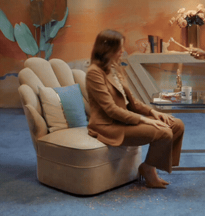Woman Sitting In Chair With Blue Pillow GIF