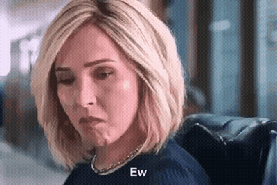 Woman Sitting In Chair With Eyes Closed Making Face GIF