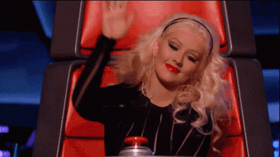 Woman Sitting In Chair With Hand Up GIF