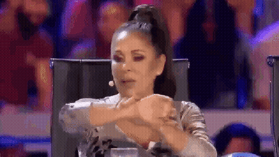 Woman Sitting In Chair With Hands Folded At Microphone GIF
