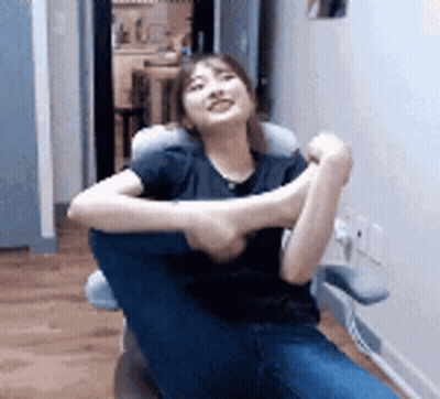 Woman Sitting In Chair With Legs Crossed And Pillow GIF