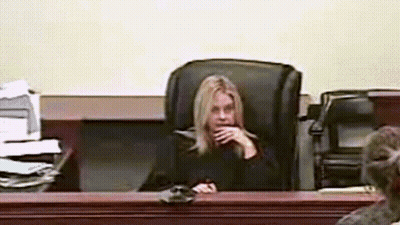 Woman Sitting In Courtroom Hand On Chin GIF