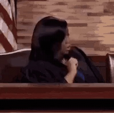 Woman Sitting In Courtroom Holding Microphone GIF