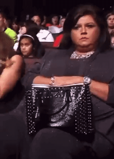 Woman Sitting In Crowd Watching Performance GIF