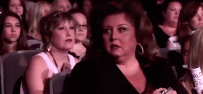 Woman Sitting In Crowd Watching Performance GIF