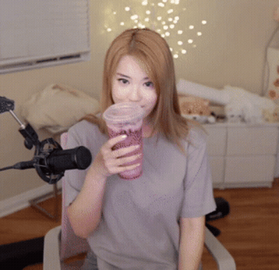 Woman Sitting In Front Of A Microphone Holding A Cup GIF