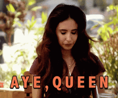 Woman Sitting In Front Of Aye Queen Sign GIF