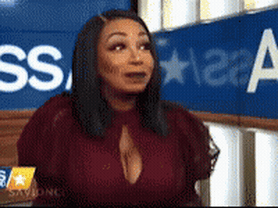 Woman Sitting In Front Of Blue Sign Saying SS GIF