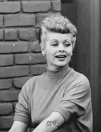 Woman Sitting In Front Of Brick Wall Smiling GIF