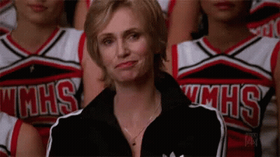 Woman Sitting In Front Of Cheerleaders In MHS Uniforms GIF