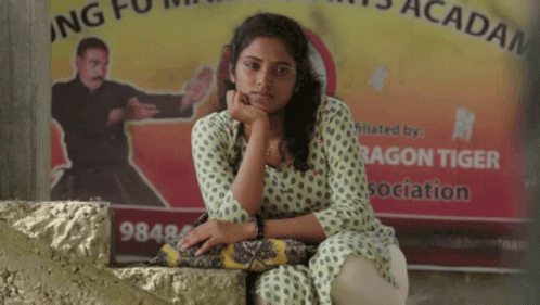 Woman Sitting In Front Of Dragon Tiger Sign GIF