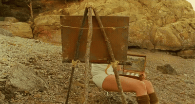 Woman Sitting In Front Of Easel With Painting GIF