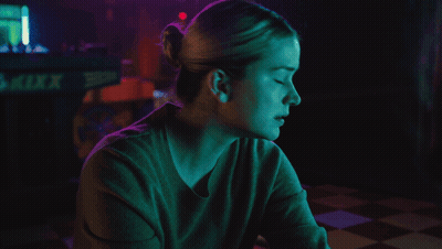 Woman Sitting In Front Of Kixx Sign GIF