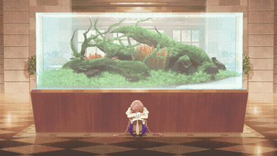 Woman Sitting In Front Of Large Aquarium GIF