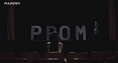 Woman Sitting In Front Of Prom Sign GIF
