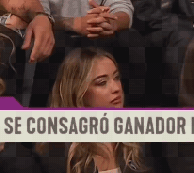 Woman Sitting in Front of Se Consagro Ganador Sign