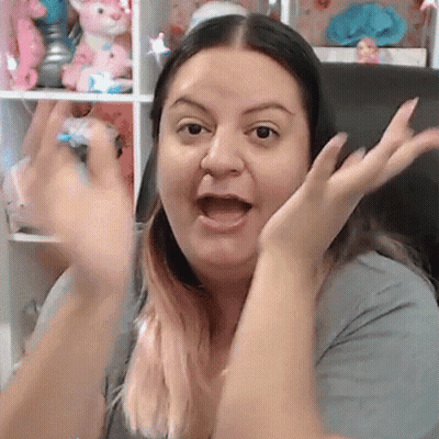 Woman Sitting In Front Of Shelf With Stuffed Animals GIF