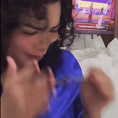 Woman Sitting In Front Of TV Saying Karina Regresa A Casa GIF