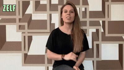 Woman Sitting In Front Of Zelf Wall GIF