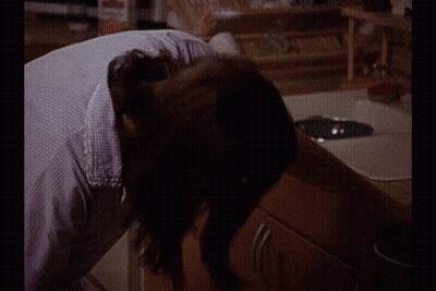 Woman Sitting In Kitchen With Coffee Maker GIF