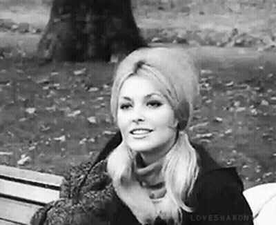 Woman Sitting In Park With Hat And Scarf GIF
