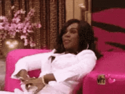 Woman Sitting In Pink Chair With VH1 Logo GIF