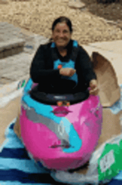 Woman Sitting In Pink Kayak On Beach Towel GIF