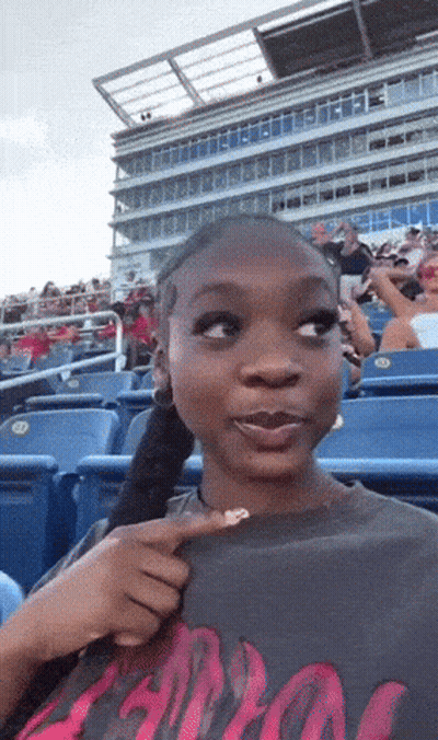 Woman Sitting In Stadium Wearing Apollo Shirt GIF