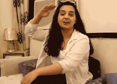 Woman Sitting On Bed Arm Outstretched GIF