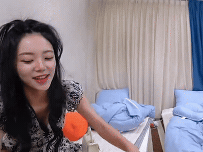 Woman Sitting On Bed Holding Pillow Smiling GIF