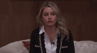 Woman Sitting On Bed In Black Cardigan With Pearls GIF