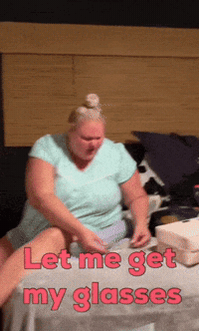 Woman Sitting On Bed Let Me Get My Glasses GIF