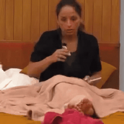 Woman Sitting On Bed With Blanket And Water Bottle GIF